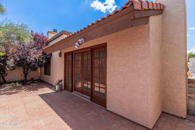 4313 N 29th Way, Phoenix, AZ 85016 - view of exterior entry with french doors, a chimney, a patio area, a tiled roof, and stucco siding