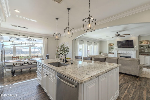 kitchen with dishwasher, pendant lighting, a kitchen island with sink, white cabinetry, and sink