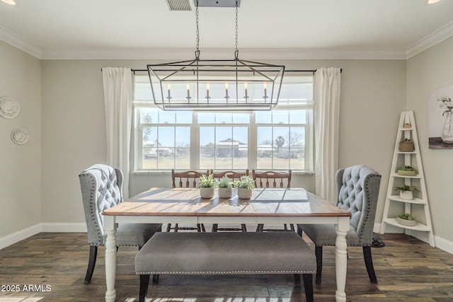 dining area featuring dark wood-type flooring, crown molding, and a healthy amount of sunlight