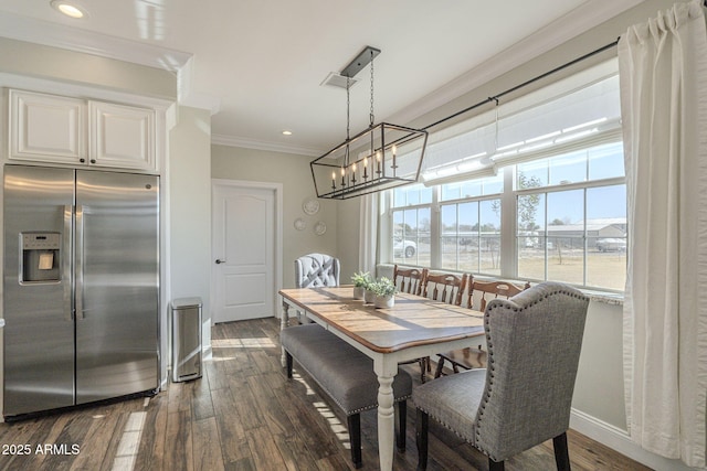 dining area with a notable chandelier, dark hardwood / wood-style flooring, and crown molding