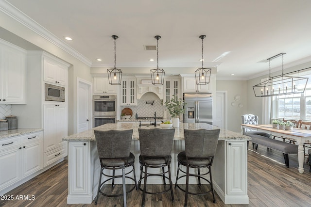 kitchen featuring stainless steel appliances, a large island, and tasteful backsplash