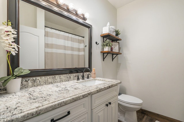 bathroom with hardwood / wood-style floors, vanity, and toilet