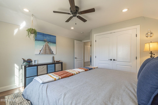 bedroom featuring wood-type flooring, a closet, ceiling fan, and vaulted ceiling