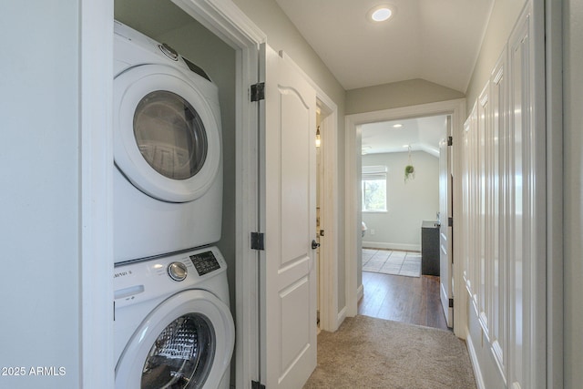 washroom with light colored carpet and stacked washer / drying machine