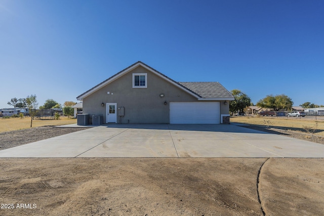 exterior space with central AC unit and a garage