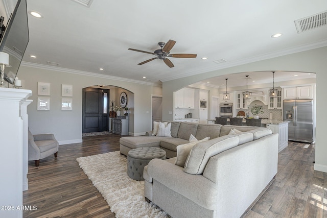 living room with ceiling fan, crown molding, and dark wood-type flooring