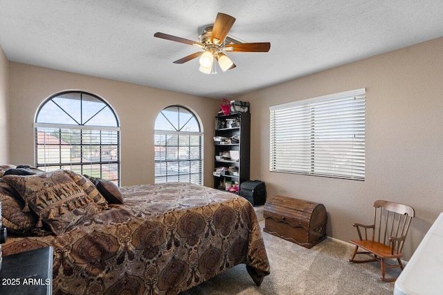 carpeted bedroom with ceiling fan and a textured ceiling