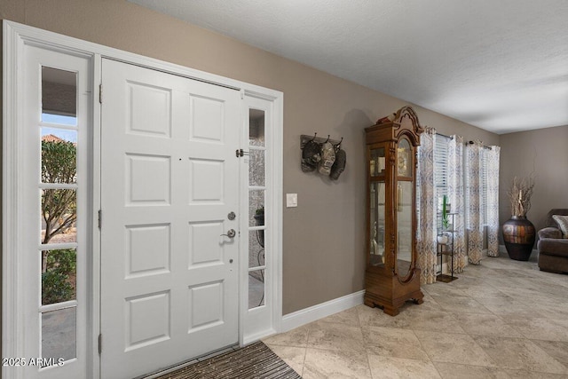 entryway featuring a textured ceiling and a wealth of natural light