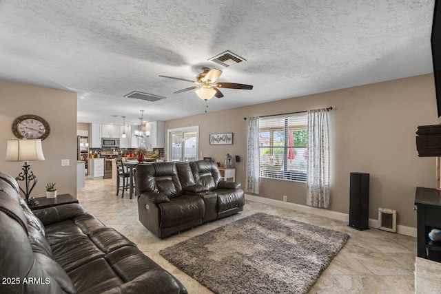 living room with ceiling fan and a textured ceiling