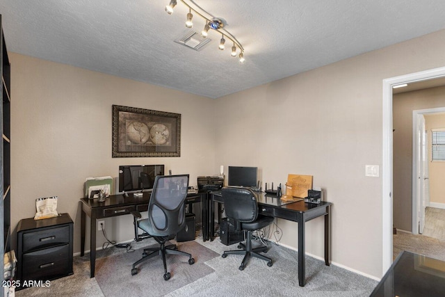 carpeted office space with a textured ceiling