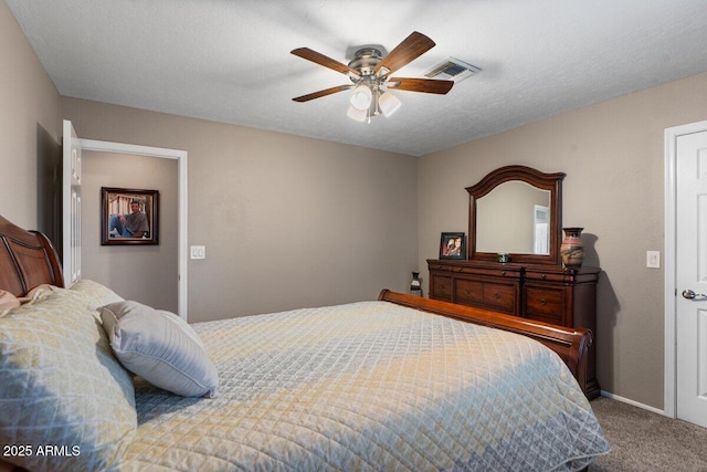 bedroom with ceiling fan, carpet floors, and a textured ceiling