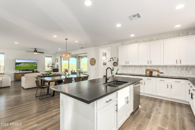 kitchen with white cabinetry, light hardwood / wood-style floors, hanging light fixtures, and sink