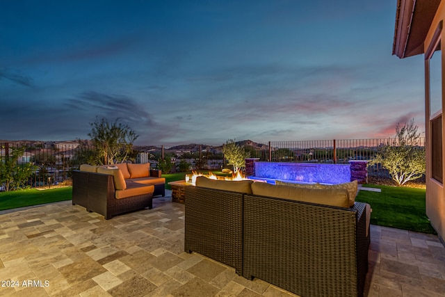 patio terrace at dusk with a swimming pool and an outdoor living space