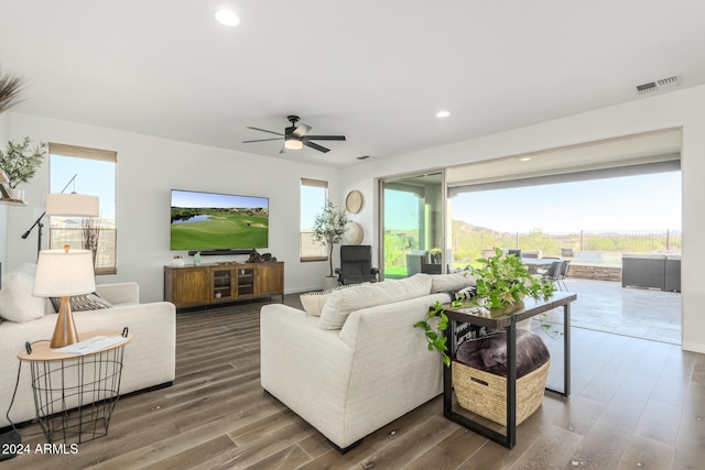 living room featuring ceiling fan and dark hardwood / wood-style flooring