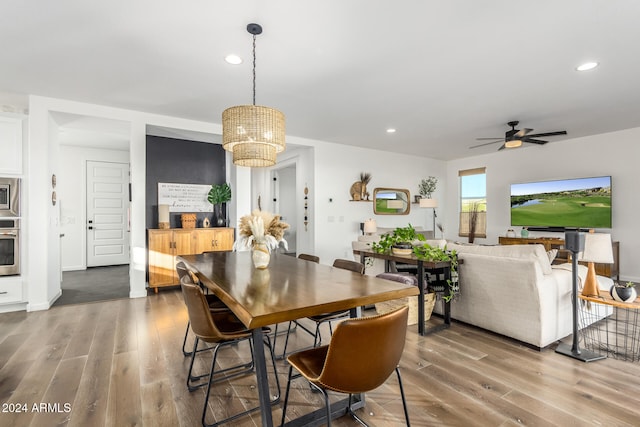 dining room featuring wood-type flooring and ceiling fan with notable chandelier