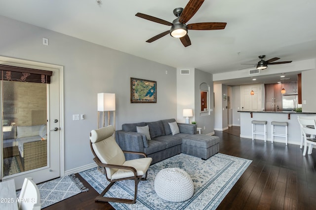 living area with visible vents, dark wood finished floors, baseboards, and ceiling fan