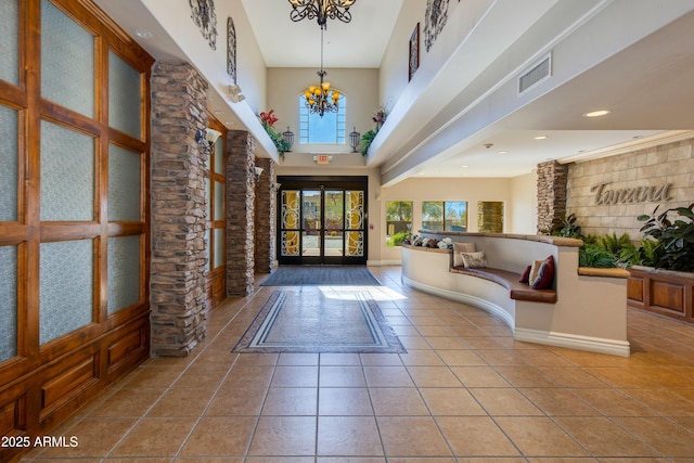 tiled entryway with a towering ceiling, visible vents, a chandelier, and recessed lighting