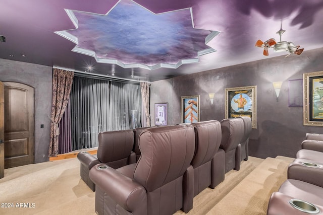 cinema featuring a raised ceiling and light carpet