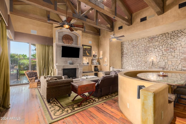 living room featuring beamed ceiling, high vaulted ceiling, wooden ceiling, and light wood-type flooring