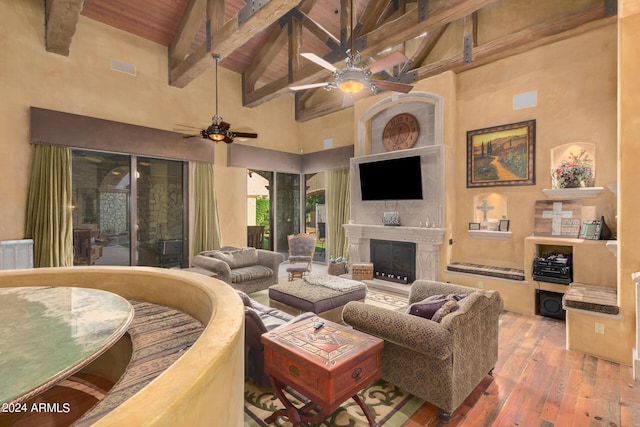 living room featuring a high end fireplace, wood ceiling, wood-type flooring, high vaulted ceiling, and beamed ceiling