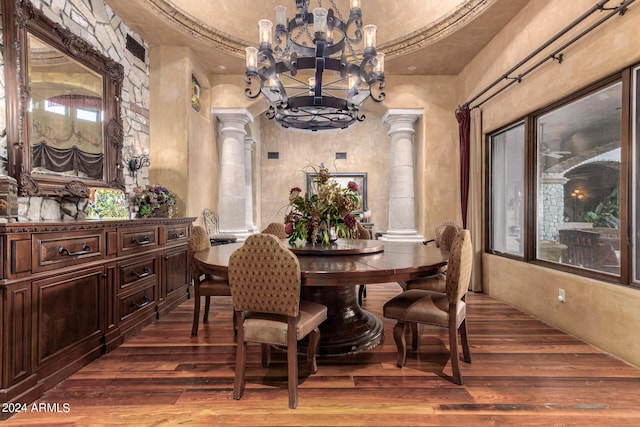 dining space with ornate columns, hardwood / wood-style floors, and a chandelier