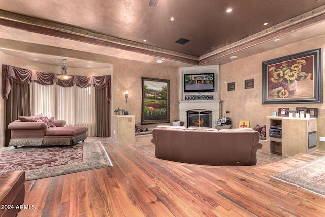 living room with wood-type flooring and a tray ceiling