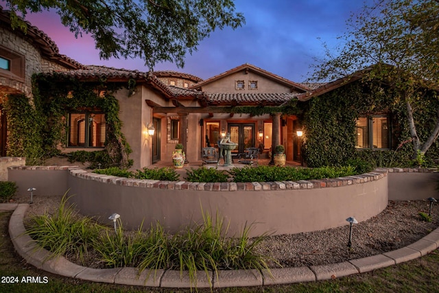 back house at dusk with french doors