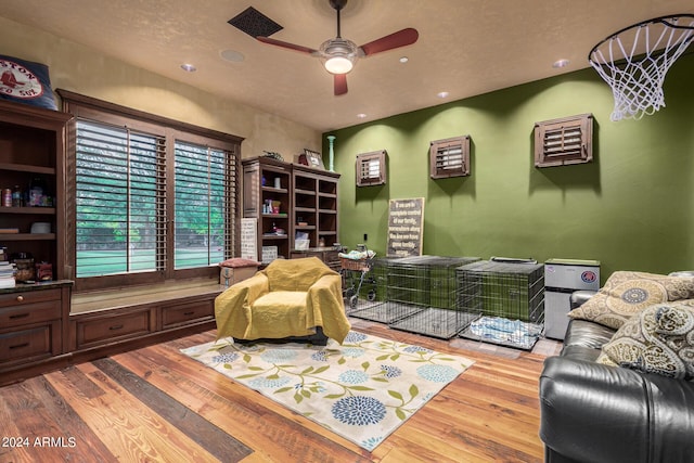 living area with ceiling fan and hardwood / wood-style floors