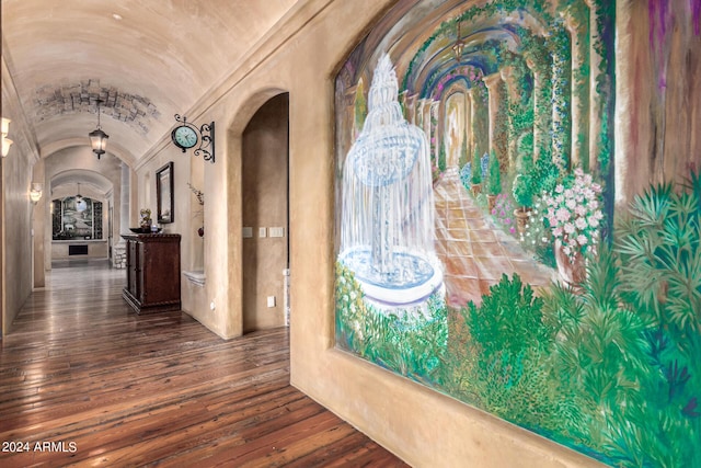 hall with hardwood / wood-style flooring, lofted ceiling, and brick ceiling