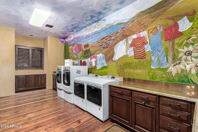 laundry room featuring cabinets, independent washer and dryer, and hardwood / wood-style floors