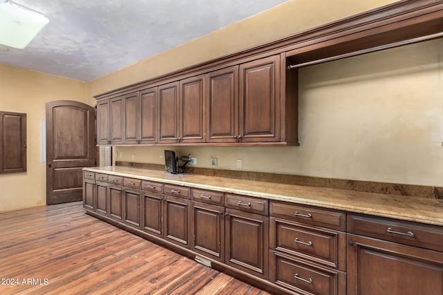 kitchen featuring dark brown cabinets and dark wood-type flooring