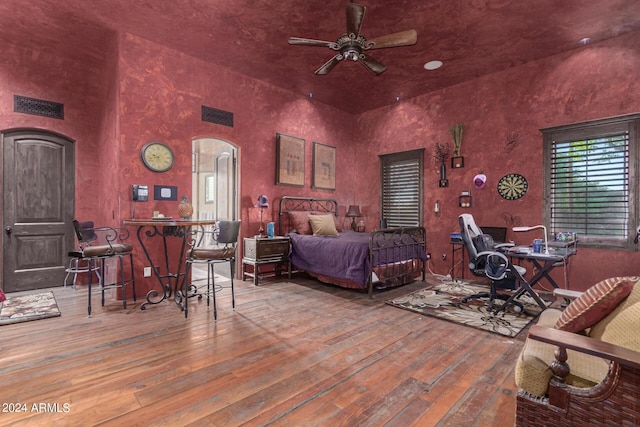 bedroom with wood-type flooring and a high ceiling