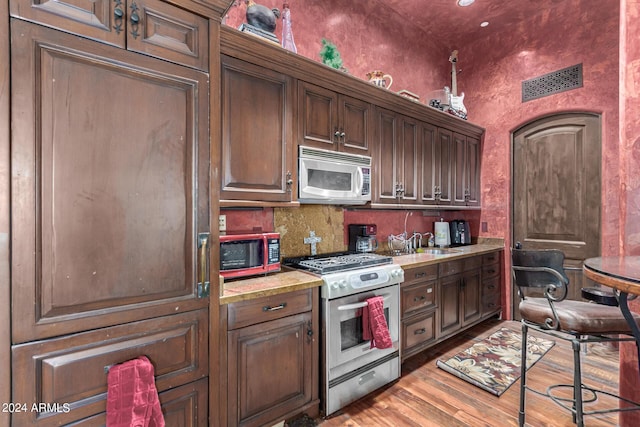 kitchen with hardwood / wood-style floors, sink, and appliances with stainless steel finishes