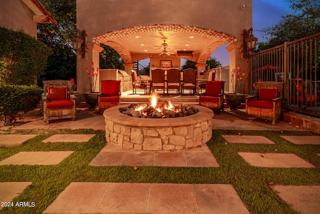 patio terrace at dusk featuring an outdoor fire pit