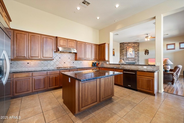 kitchen featuring decorative backsplash, light tile patterned flooring, dark stone countertops, and stainless steel appliances