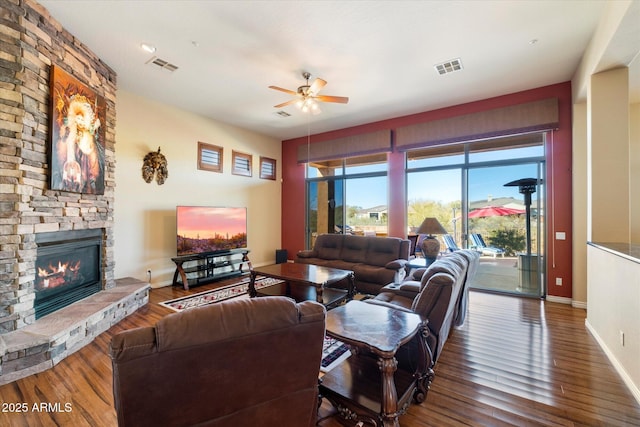 living room featuring a fireplace, hardwood / wood-style flooring, and ceiling fan