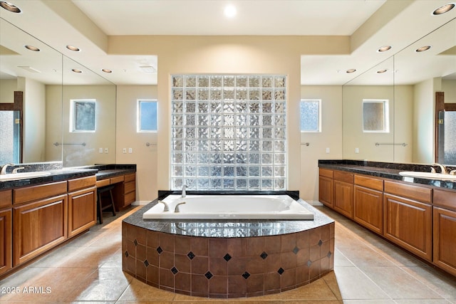 bathroom with vanity, tile patterned floors, and tiled tub