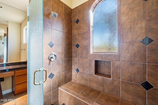 bathroom with tile patterned flooring, plenty of natural light, an enclosed shower, and vanity