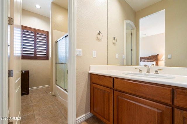 bathroom with tile patterned flooring, vanity, and bath / shower combo with glass door