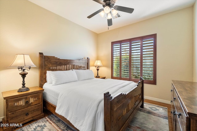 bedroom with ceiling fan and dark hardwood / wood-style floors