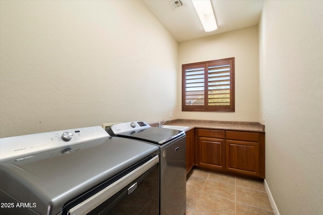 clothes washing area featuring cabinets, independent washer and dryer, sink, and light tile patterned floors