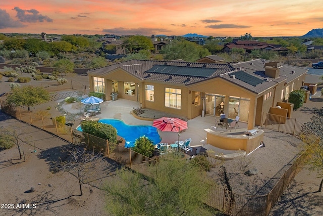 pool at dusk featuring a patio