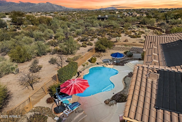 pool at dusk featuring a mountain view