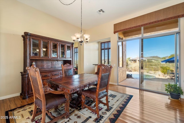 dining room featuring a mountain view, light wood-type flooring, and an inviting chandelier