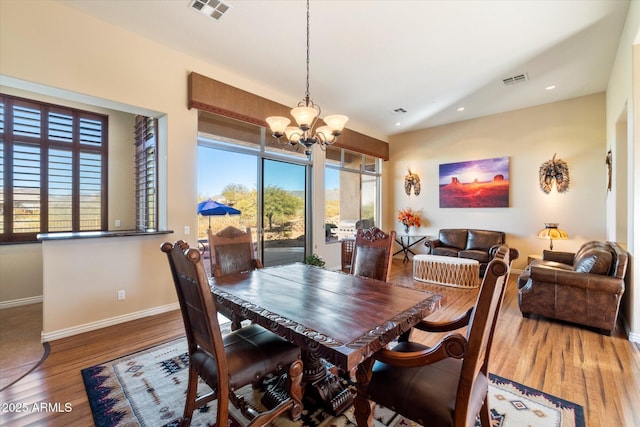 dining space featuring hardwood / wood-style flooring and a notable chandelier