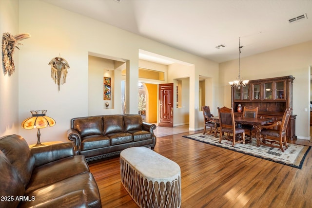 living room with a notable chandelier and wood-type flooring