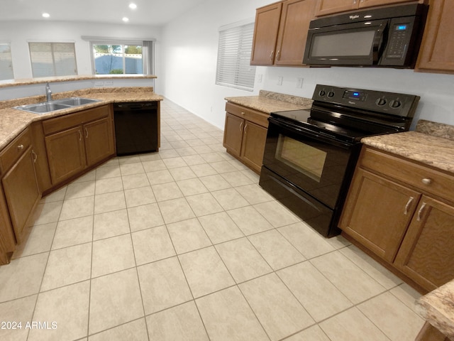 kitchen with black appliances, sink, and light tile patterned floors