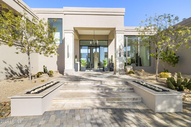 view of exterior entry with a patio area