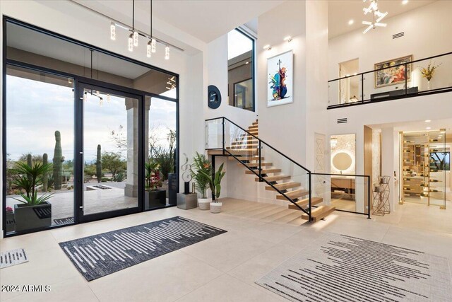 tiled foyer featuring a high ceiling and track lighting