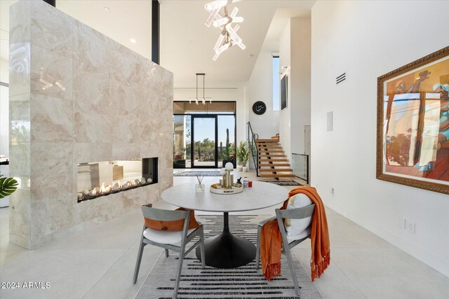 tiled dining room featuring a fireplace and a chandelier